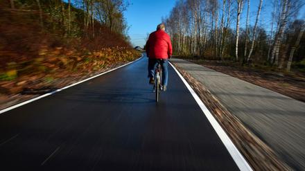 Ein Radfahrer befährt am 26.11.2015 das erste Teilstück der sogenannten Fahrradautobahn in Mülheim an der Ruhr (Nordrhein-Westfalen). Die Trasse soll nach ihrer Fertigstellung auf einer Länge von insgesamt 101 Kilometern zwischen Duisburg, Essen und Dortmund bis nach Hamm verlaufen. Parallel verläuft auch ein Fußweg. 