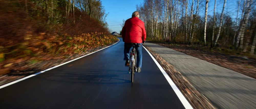 Ein Radfahrer befährt am 26.11.2015 das erste Teilstück der sogenannten Fahrradautobahn in Mülheim an der Ruhr (Nordrhein-Westfalen). Die Trasse soll nach ihrer Fertigstellung auf einer Länge von insgesamt 101 Kilometern zwischen Duisburg, Essen und Dortmund bis nach Hamm verlaufen. Parallel verläuft auch ein Fußweg. 