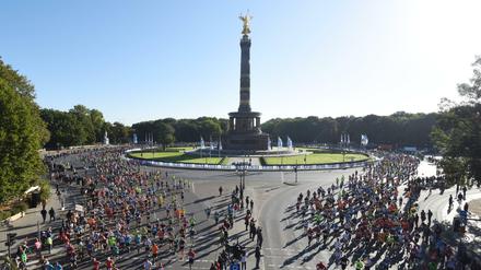 Zahlreiche Teilnehmer laufen am 27.09.2015 beim 42. Berlin-Marathon an beiden Seiten der Siegessäule in Berlin vorbei. 