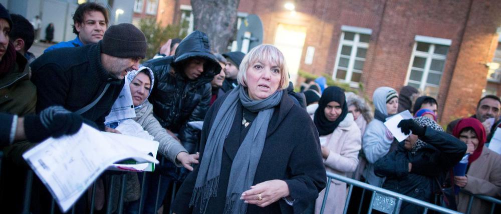 Die Bundestagsvizepräsidentin Claudia Roth (Bündnis 90/Die Grünen) steht am 30.11.2015 am frühen Morgen mit wartenden Flüchtlingen vor dem Landesamt für Gesundheit und Soziales (LaGeSo) in Berlin.