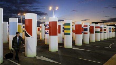 Durch diese Säulen mit den Länderflaggen gehen die Delegierten beim Pariser Klimagipfel jeden Morgen. Viele kommen, solange es noch dunkel ist und verlassen das Gelände nachts wieder. 