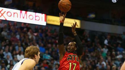 Dennis Schröder hebt ab, Dirk Nowitzki schaut zu.