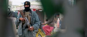 Ein Mitglied der afghanischen Sicherheitskräfte sichert am Dienstag, den 8. Dezember 2015 das Gebiet um eine Polizeistation, die von Taliban angegriffen wurde. Gleichzeitig wurde offenbar der Flughafen von Kandahar von Taliban erobert.