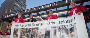 Mitarbeiter des Bahnwerks Eberswalde halten während einer Mahnwache für den Erhalt ihrer Arbeitsplätze am 05.10.2015 auf dem Potsdamer Platz in Berlin (Deutschland) ein Transparent mit der Aufschrift «Wir kämpfen für unsere Arbeitsplätze!» in den Händen. 
