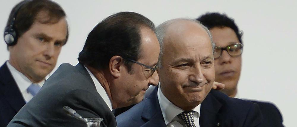 Frankreichs Präsident Francois Hollande (links) dankt seinem Außenminister und und Konferenzleiter Laurent Fabius für sein Ringen um ein Klimaschutzabkommen.