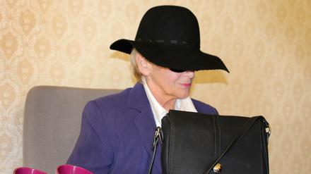 Die Angeklagte sitzt am 27.03.2014 in Meschede (Nordrhein-Westfalen) zu Beginn des Prozesses im Gerichtssaal. Die Frau soll einen Pfarrer gestalkt haben.