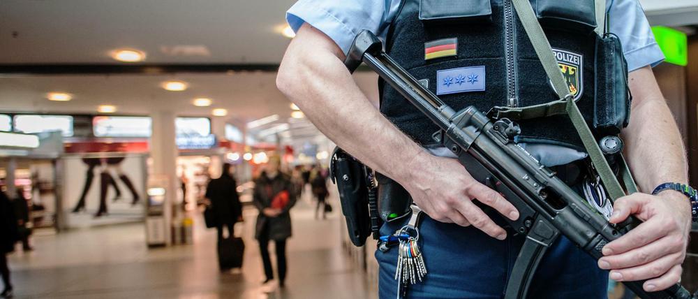 Ein bewaffneter Polizist steht am 18.11.2015 in Berlin im Flughafen Tegel. Nach den Terroranschlägen von Paris wurden die Sicherheitsvorkehrungen auf öffentlichen Plätzen und in bestimmten öffentlichen Gebäuden verstärkt.
