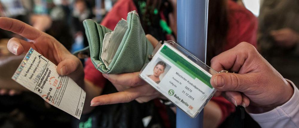 Eine Kontrolleurin lässt sich in der Berliner S-Bahn einen Fahrausweis zeigen.