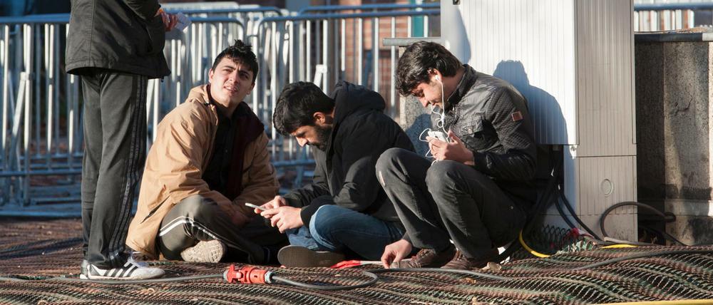 Flüchtlinge aus Pakistan unterhalten sich auf dem Gelände des Landesamtes für Gesundheit und Soziales (LaGeSo) in Berlin.