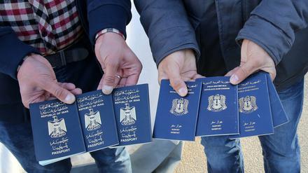 Transitflüchtlinge zeigen Pässe aus dem Irak und Syrien. 