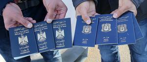 Transitflüchtlinge zeigen Pässe aus dem Irak und Syrien. 