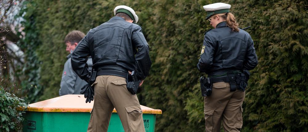 Zwei Polizisten begutachten am Montag in Bayreuth nach einer Schießerei mit drei Toten und einem Schwerverletzten den Bereich eines Tatortes.