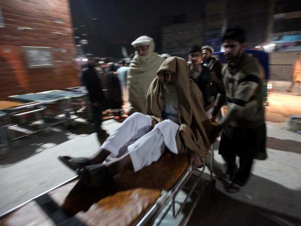 Helfer bringen ein Erdbebenopfer ins Krankenhaus im pakistanischen Peschawar.