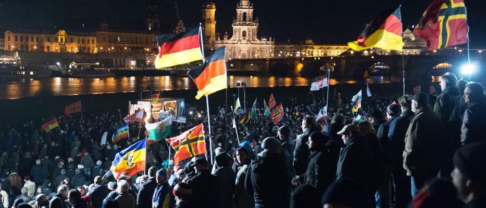 Teilnehmer haben sich am 21.12.2015 am Königsufer in Dresden (Sachsen) bei einer Kundgebung des Bündnisses Pegida (Patriotische Europäer gegen die Islamisierung des Abendlandes) versammelt.
