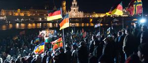 Teilnehmer haben sich am 21.12.2015 am Königsufer in Dresden (Sachsen) bei einer Kundgebung des Bündnisses Pegida (Patriotische Europäer gegen die Islamisierung des Abendlandes) versammelt.