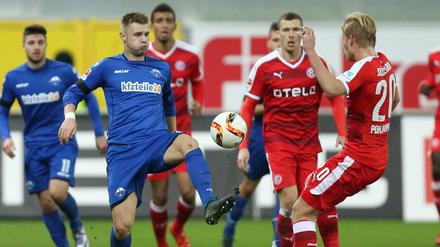 Paderborns Florian Hartherz (l) im Kampf um den Ball mit Joel Pohjanpalo (r) aus Düsseldorf.