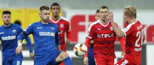 Paderborns Florian Hartherz (l) im Kampf um den Ball mit Joel Pohjanpalo (r) aus Düsseldorf.