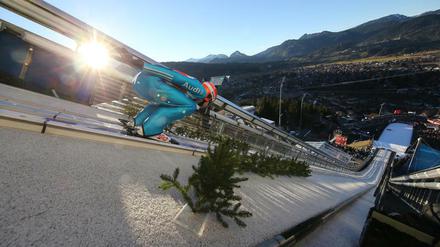 Da schien noch die Sonne. Der Deutsche Pius Paschke bei seinem Trainingssprung. Später fiel in Oberstdorf für 75 Minuten das Flutlicht aus.
