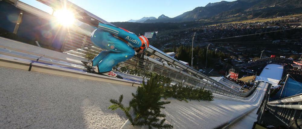 Da schien noch die Sonne. Der Deutsche Pius Paschke bei seinem Trainingssprung. Später fiel in Oberstdorf für 75 Minuten das Flutlicht aus.