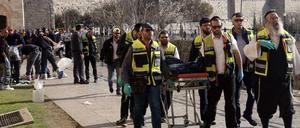 Helfer bringen die Leiche eines der beiden palästinensischen Angreifers fort.