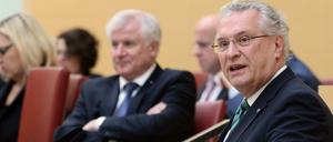 Der bayerische Innenminister Joachim Herrmann (r) spricht am 08.12.2015 bei einer Plenarsitzung im Bayerischen Landtag in München (Bayern), während im Hintergrund der bayerische Ministerpräsident Horst Seehofer (beide CSU) sitzt und zuhört. 