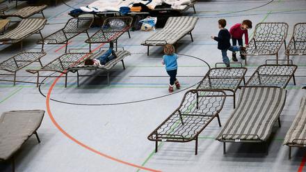 Flüchtlinge in einer Sporthalle. Das lindert die Not der Menschen, ist für eine Belastung für Vereine.