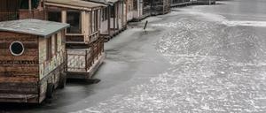 Die Holzhäuser am Landwehrkanal in Berlin sind inzwischen fast von einer Eisschicht umgeben. 