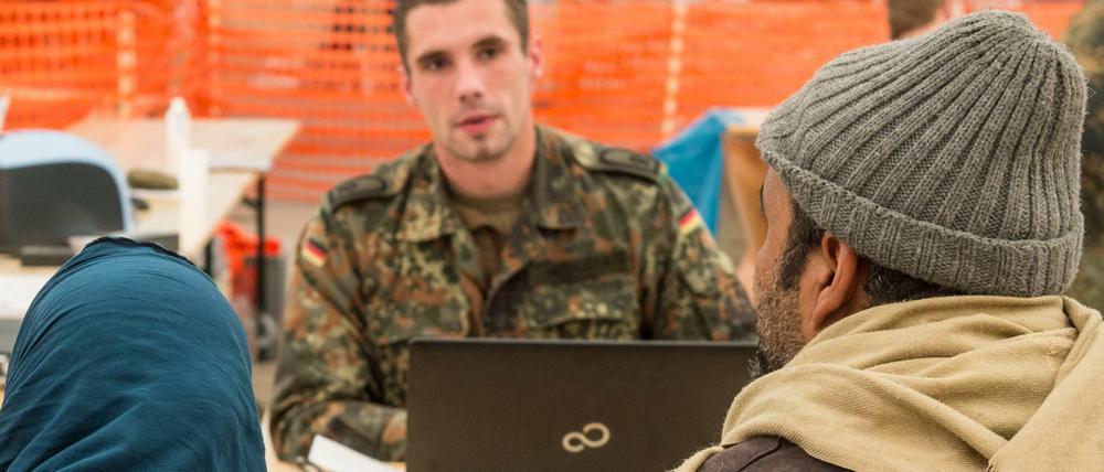 Willkommen in Deutschland. Ein Hauptfeldwebel begrüßt im Wartezentrum in Erding (Bayern) eine Familie aus dem Irak. 