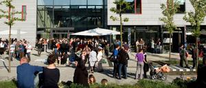 Menschen stehen vor einem Hochschulgebäude