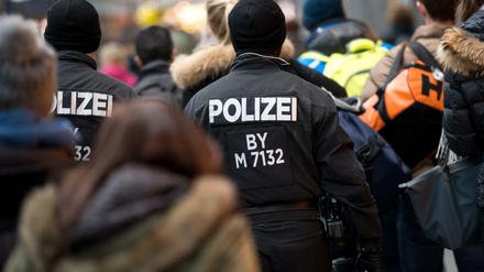 Polizisten und Passanten gehen am 02.01.2016 in München (Bayern) durch den Hauptbahnhof. Nach dem Terroralarm von München fahnden die Sicherheitsbehörden weiter nach islamistischen Extremisten. 