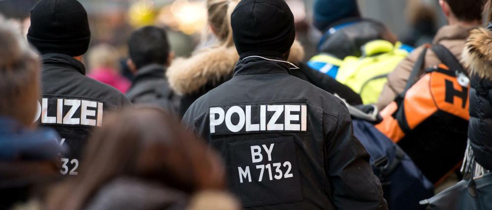 Polizisten und Passanten gehen am 02.01.2016 in München (Bayern) durch den Hauptbahnhof. Nach dem Terroralarm von München fahnden die Sicherheitsbehörden weiter nach islamistischen Extremisten.