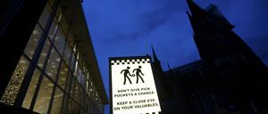 Vor dem Kölner Hauptbahnhof warnt ein Schild vor Taschendieben.