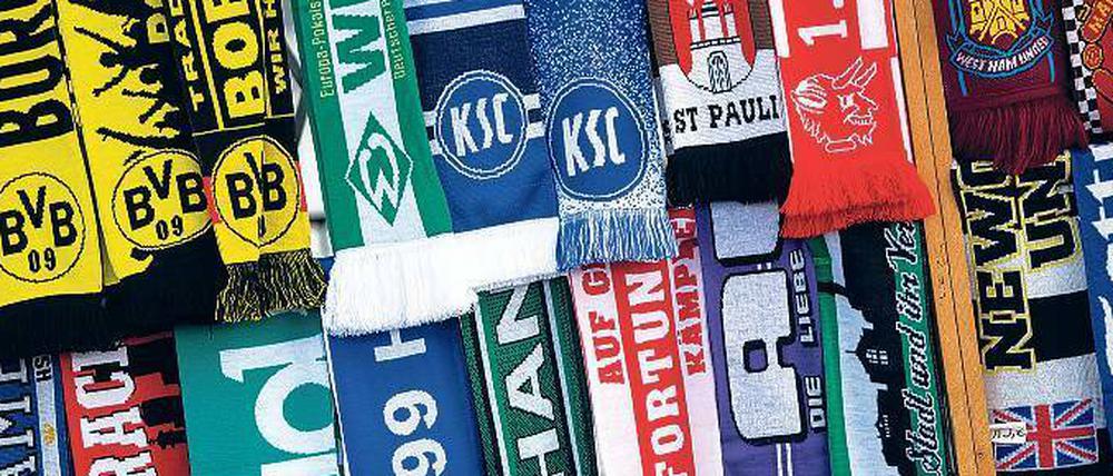 Schön bunt. Viele Fußballanhänger gehen in voller Montur ins Stadion.