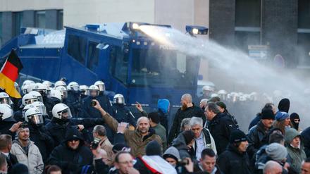 Die Polizei geht mit einem Wasserwerfer gegen die Pegida-Versammlung vor.