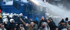 Die Polizei geht mit einem Wasserwerfer gegen die Pegida-Versammlung vor.