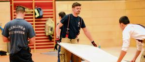 Berliner Feuerwehr und zivile Helfer errichten gemeinsam in einer Turnhalle in der Hausburgstrasse in Berlin-Friedrichshain eine Notunterkunft für Flüchtlinge.