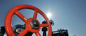 Ein rotes Drehrad an einer Hochdruckleitung in der Mineralölraffinerie. 