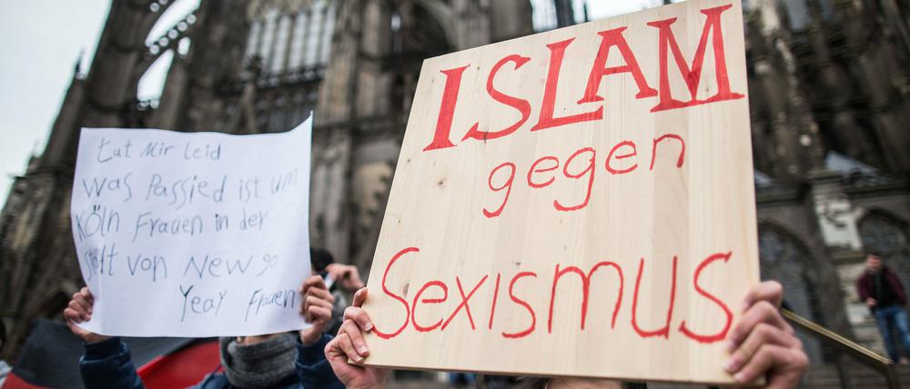 Ein Mann aus Syrien steht am Sonntag in Köln vor dem Hauptbahnhof und dem Dom mit einem Plakat "Islam gegen Sexismus". In Köln waren am Silvesterabend nach Polizeiangaben auf dem Platz vor dem Hauptbahnhof zahlreiche Frauen im Getümmel sexuell bedrängt und bestohlen worden.