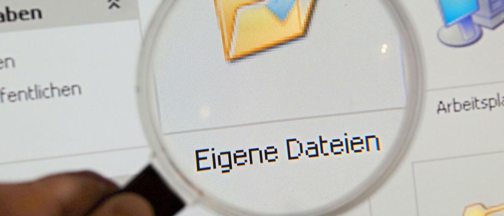 Eine Lupe wird vor den Ordner "Eigene Dateien" auf einem Computermonitor gehalten.