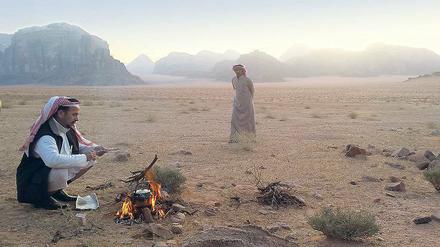 Kaffee zum Sonnenaufgang. Frühmorgens haben diese beiden Beduinen im Wadi Rum ein Feuer angezündet. Von hier starten Kameltouren. 