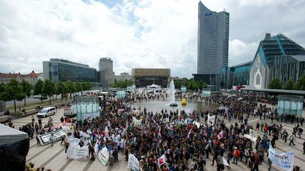 Studierende stehen mit Transparenten auf einem Platz und protestieren.