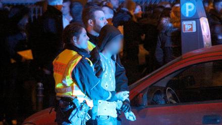 Ein Mann wird Silvester in Köln von Polizeibeamten abgeführt. Am Hauptbahnhof waren Frauen sexuell belästigt und ausgeraubt worden.