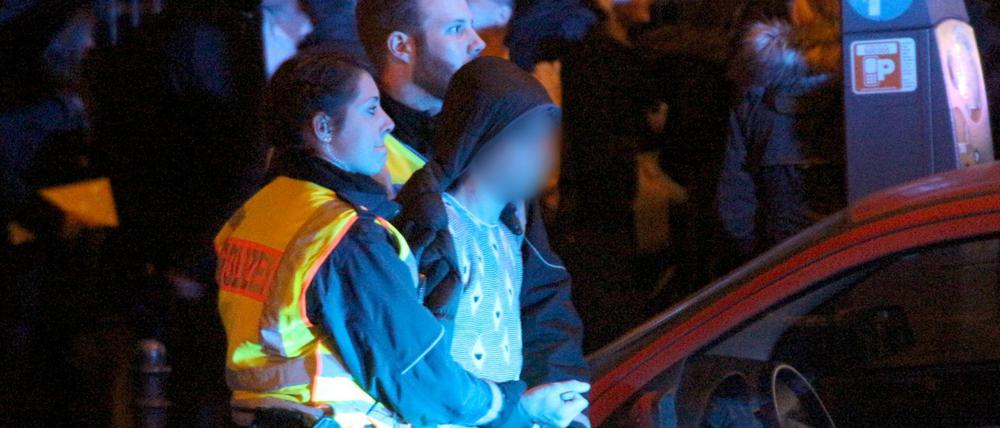 Ein Mann wird Silvester in Köln von Polizeibeamten abgeführt. Am Hauptbahnhof waren Frauen sexuell belästigt und ausgeraubt worden.