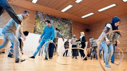 Hauptsache Spaß. 21 Flüchtlinge werden derzeit beim Landessportbund zu Übungsleitern im Breitensport ausgebildet. Zum Programm gehören dabei auch Spiele wie der Reifentwist. Außerdem absolvieren die Teilnehmer jeweils ein Betriebspraktikum.