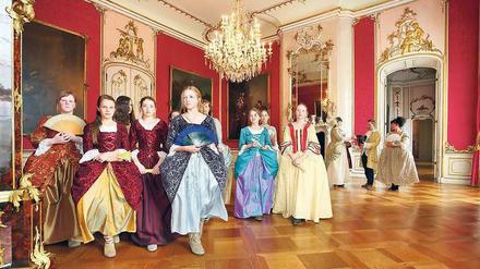 Im Neuen Palais in Potsdam tanzen Geburtstagskinder in Seidenkleidern. 