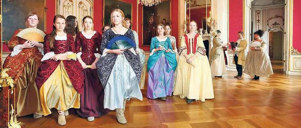 Im Neuen Palais in Potsdam tanzen Geburtstagskinder in Seidenkleidern.