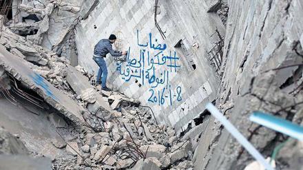 Ein Bewohner der halb zerstörten syrischen Stadt Kafr Batna protestiert mit wütenden Graffiti gegen die Belagerung von Madaja durch syrische Truppen.