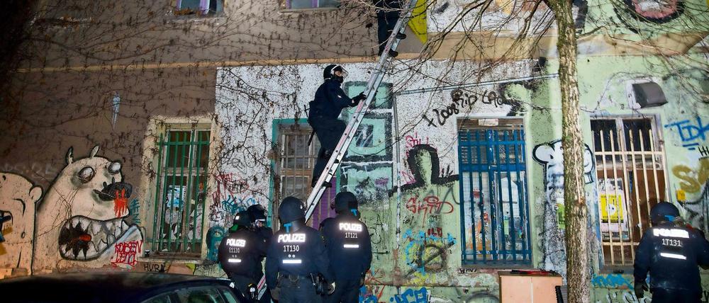 Polizisten steigen über eine Leiter in die Liebigstraße 34.