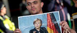 Kritiker werfen Angela Merkel vor, dass sie mit ihrer Politik zu viele Flüchtlinge ermuntert, nach Deutschland zu kommen. 