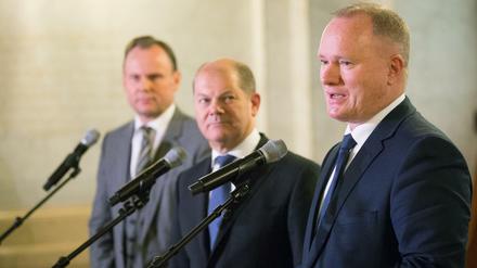 Hamburgs zurückgetretener Innensenator Michael Neumann (SPD, r) spricht am 18.01.2016 im Rathaus in Hamburg an der Seite von Hamburgs Erstem Bürgermeister Olaf Scholz (SPD) und dem Chef des Bezirksamts Mitte, Andy Grote (SPD, l). Grote wird Nachfolger von Hamburgs zurückgetretenem Innensenator Neumann. 